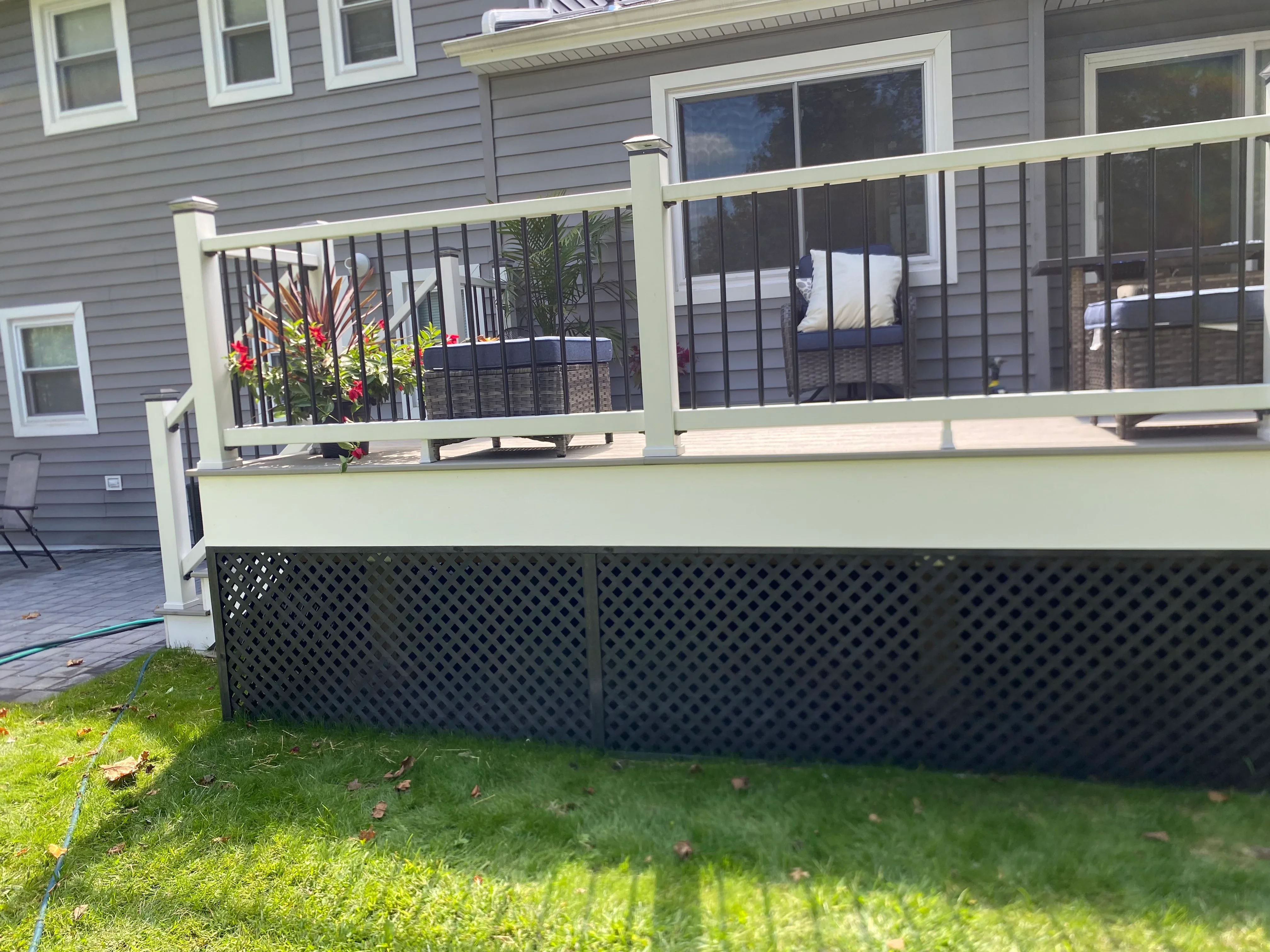 Cream deck with black metal railing and lattice skirting on elevated platform