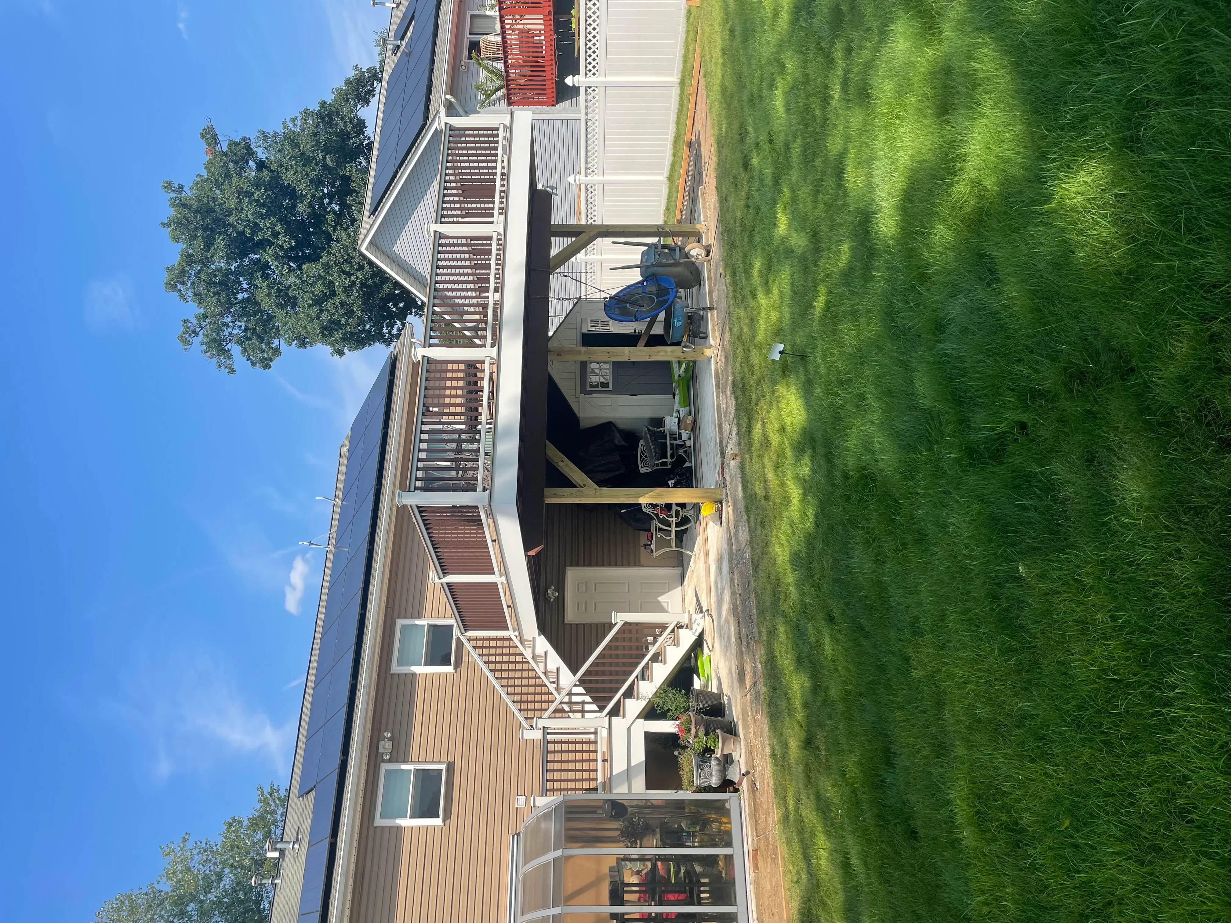Metal-sided garage addition with white trim and driveway extension