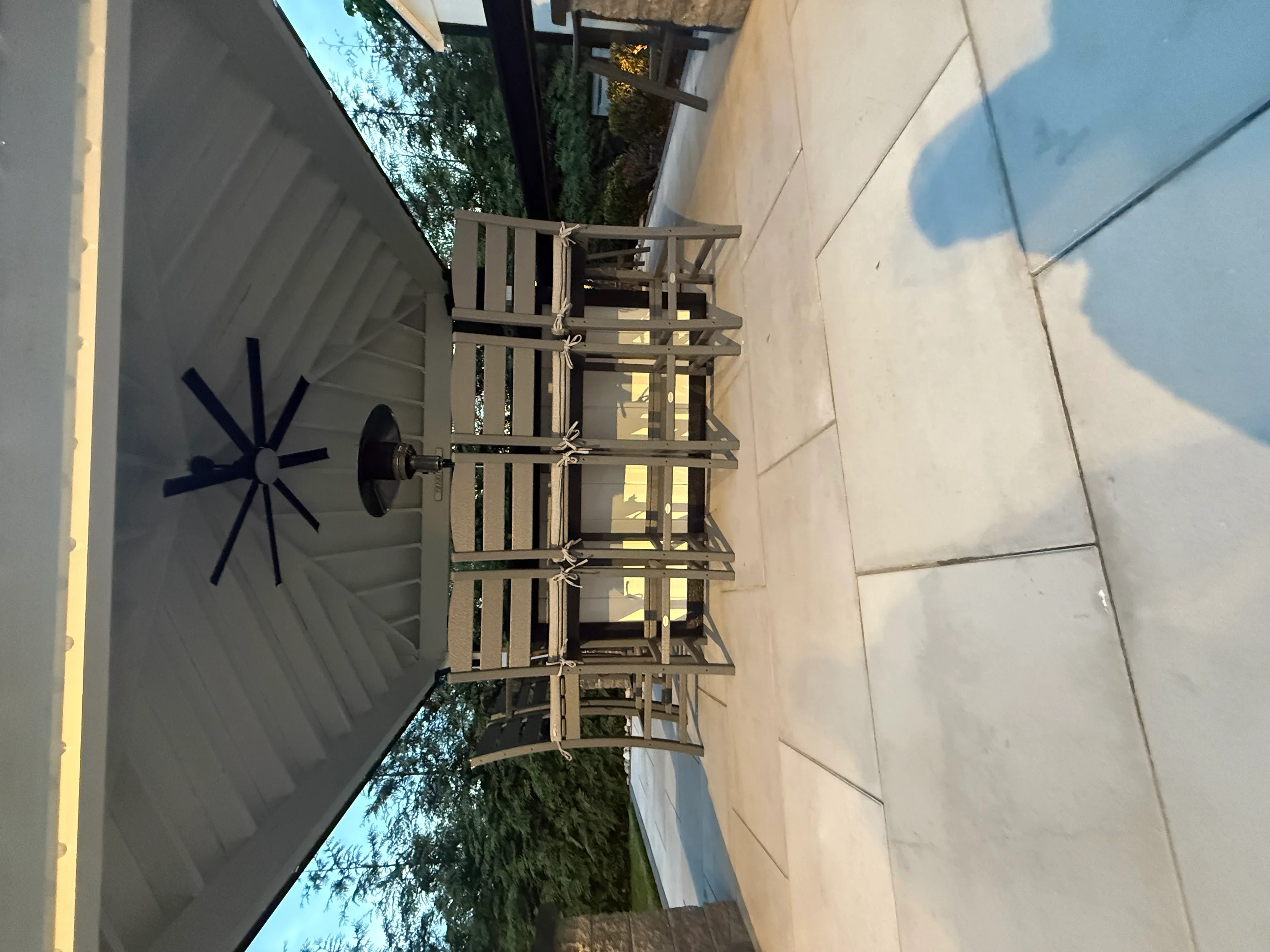 Multi-tier composite deck with metal railings and horizontal slats overlooking patio