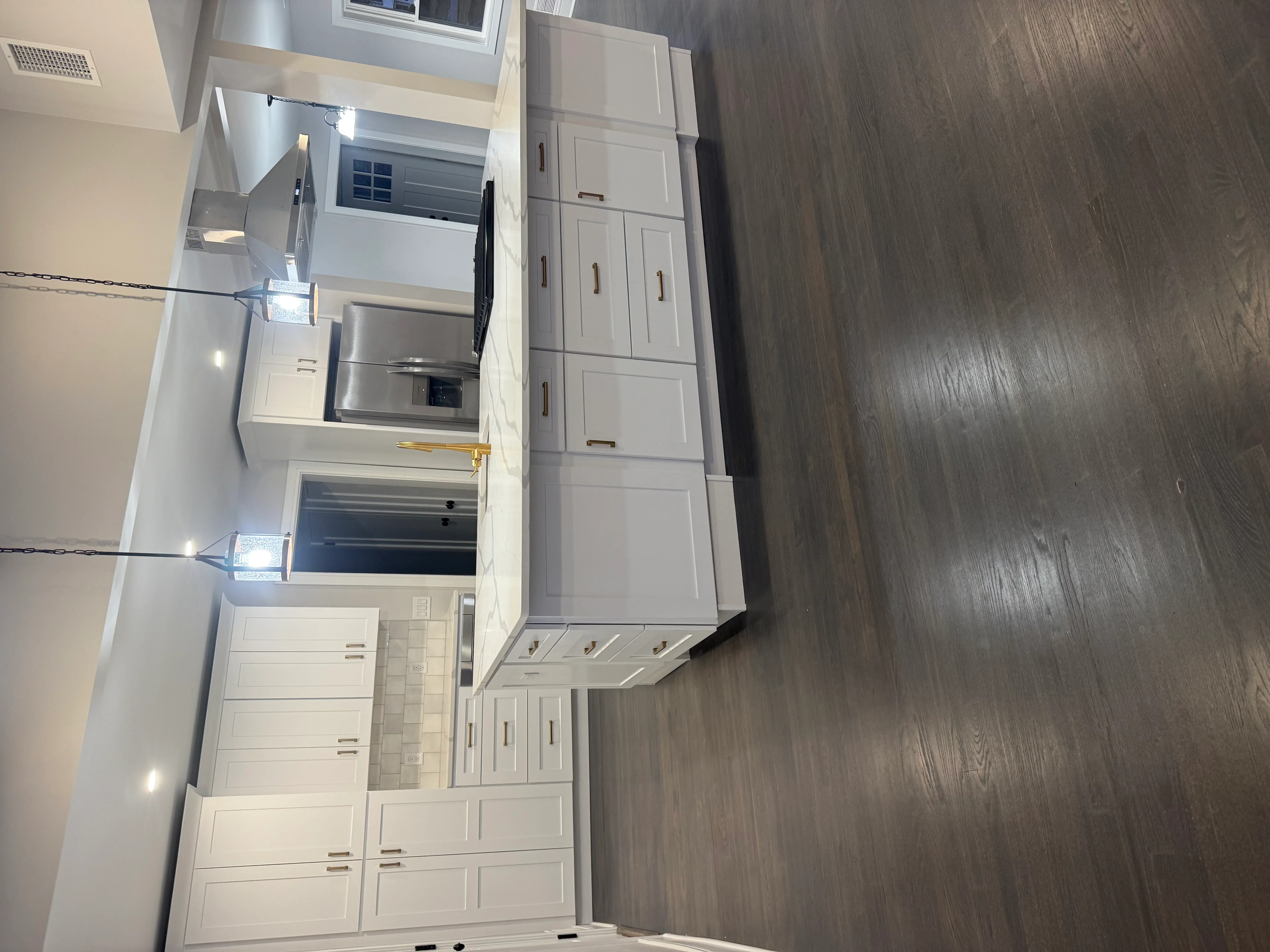 White cabinetry kitchen with stainless steel appliances, gray vinyl flooring, and recessed lighting