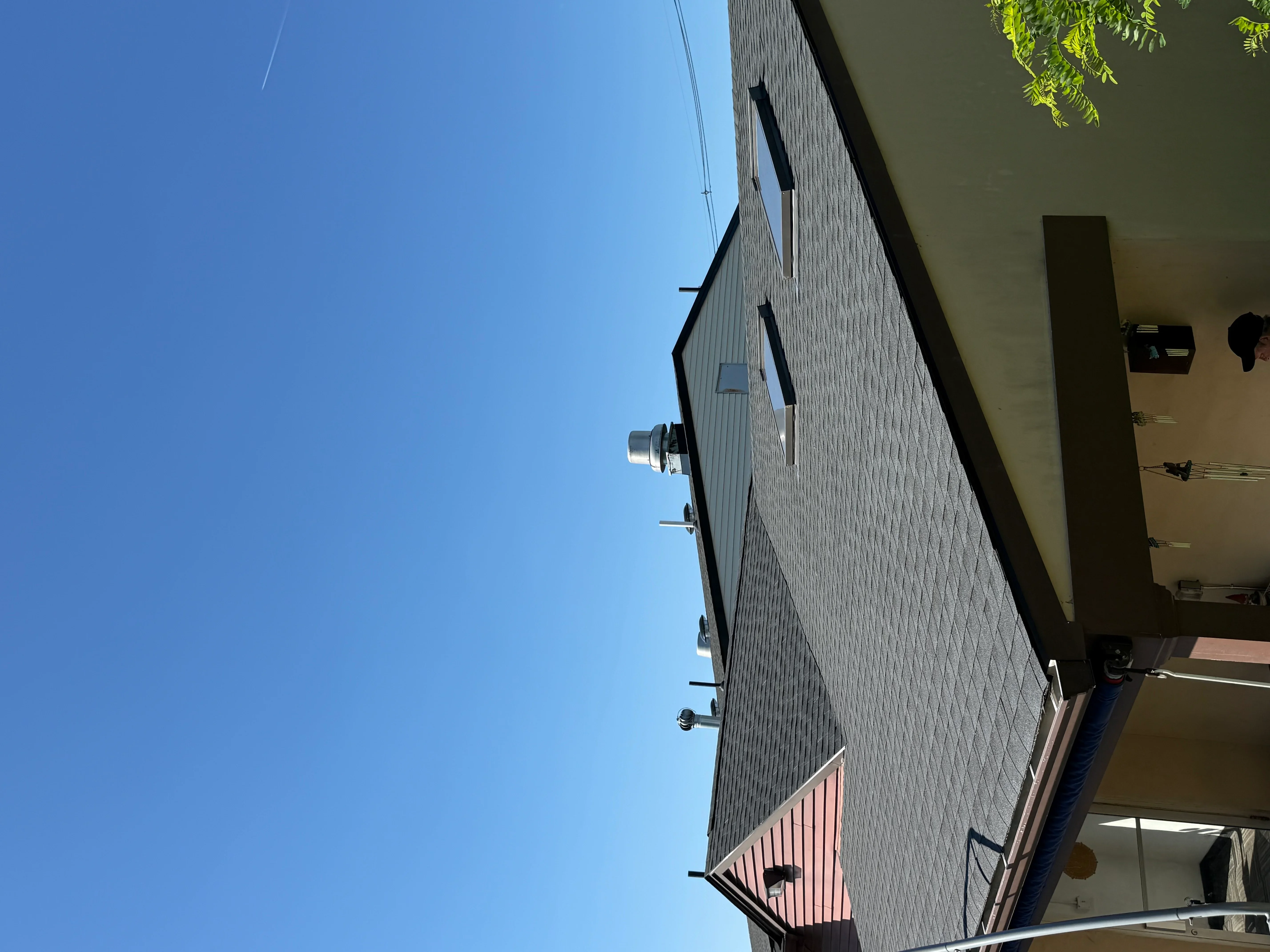 Gray dimensional asphalt shingle roof with red metal accent panel and installed flashing