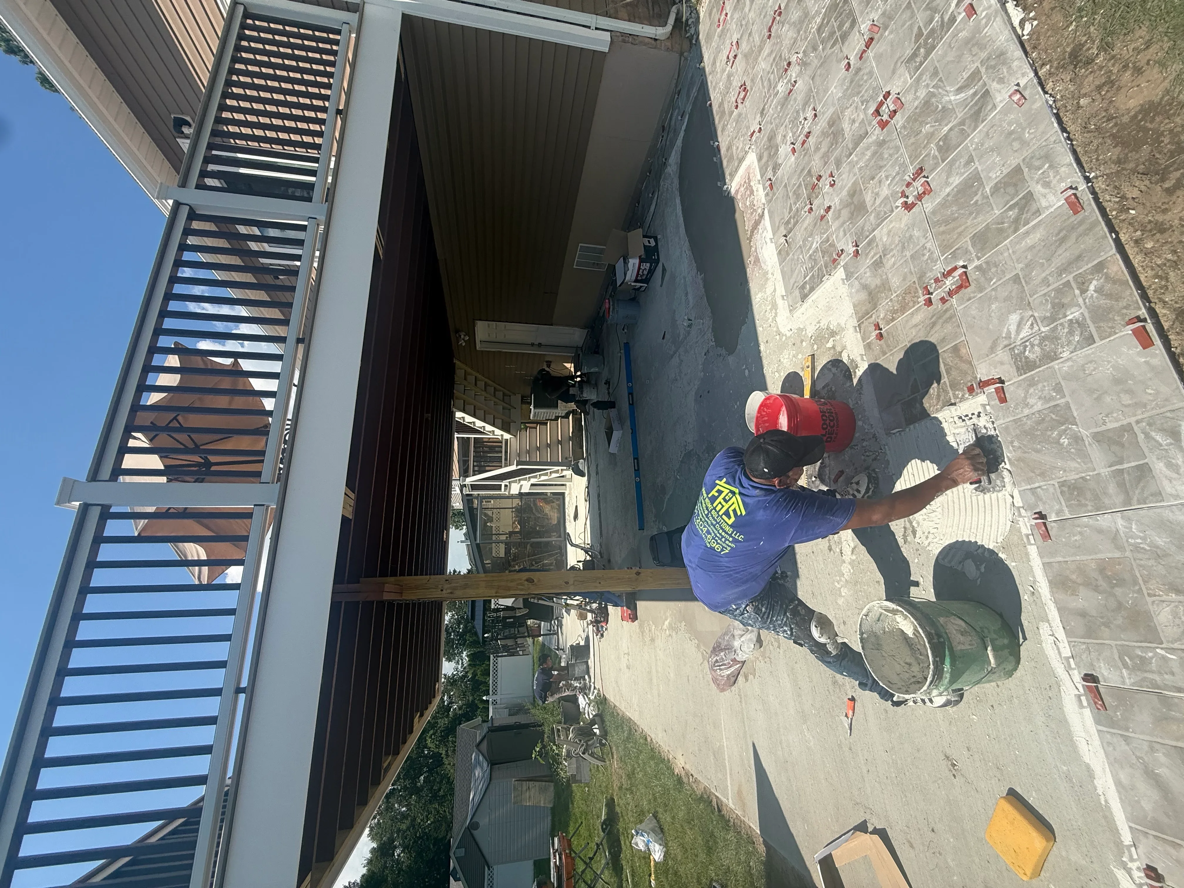 Worker applying waterproof sealant to exterior brick wall with protective coating