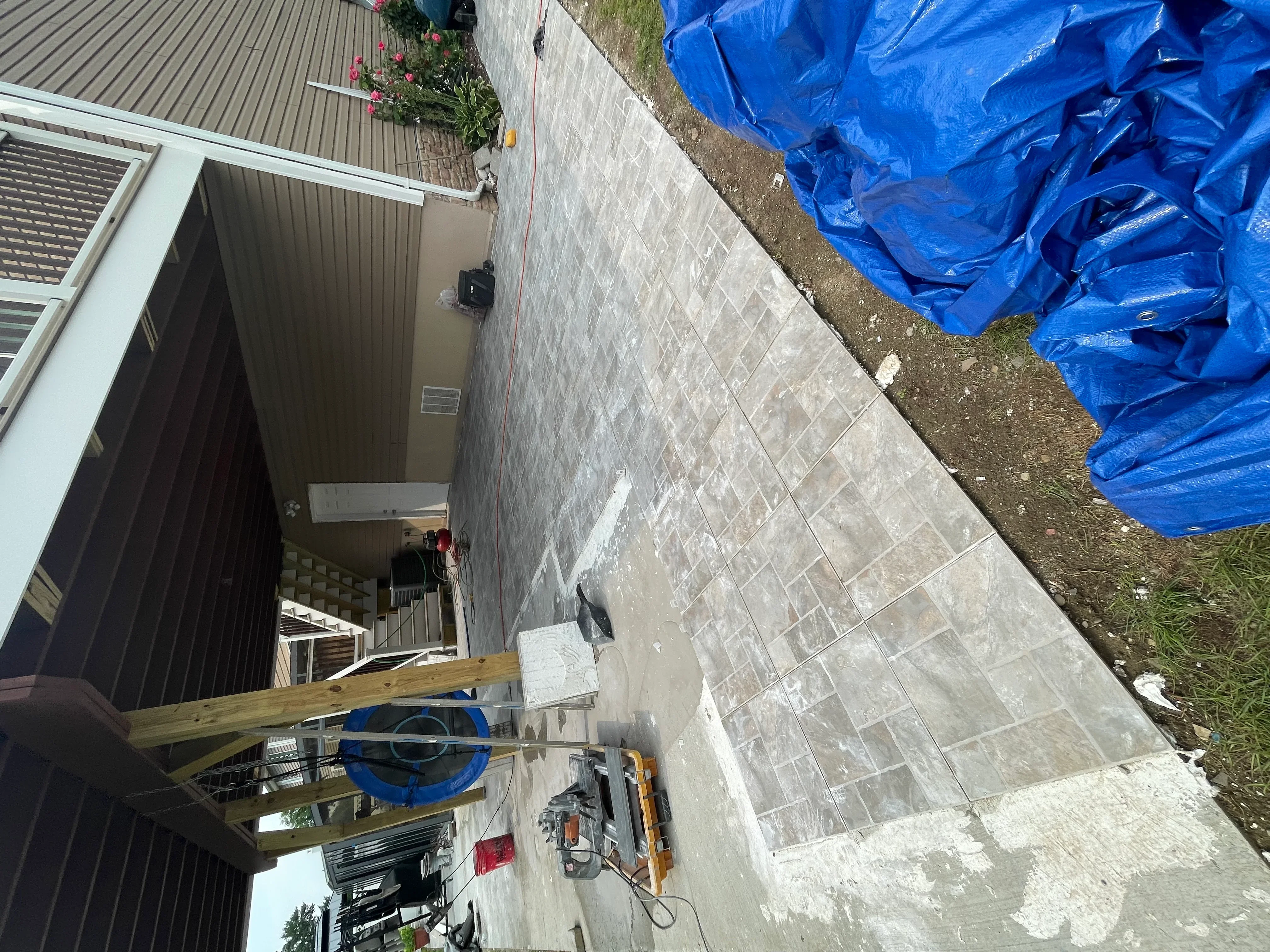 Exterior concrete patio with large-format tile installation and grout lines in progress