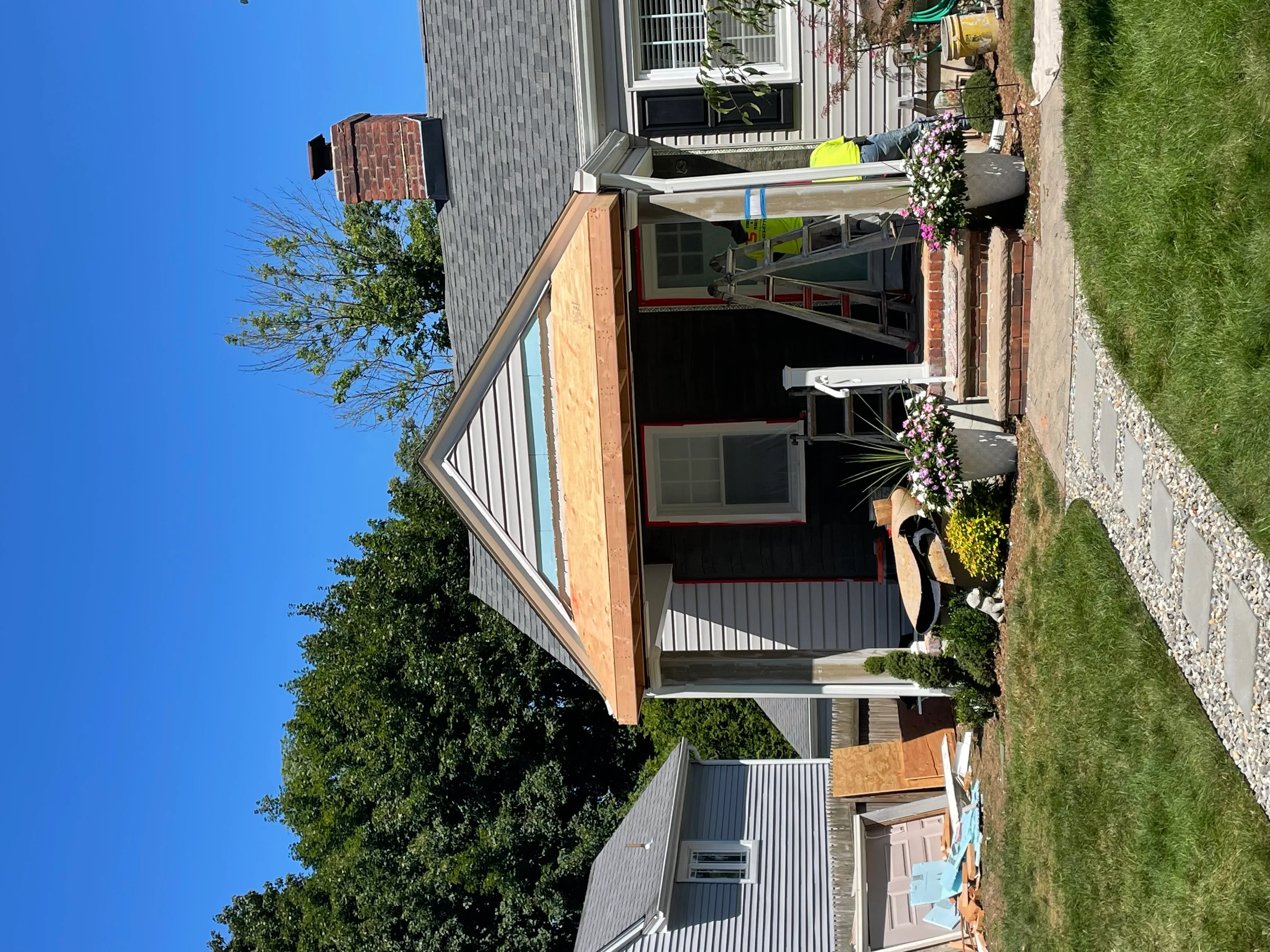 Kitchen remodel with new cabinetry, countertops, and updated home exterior with siding and windows