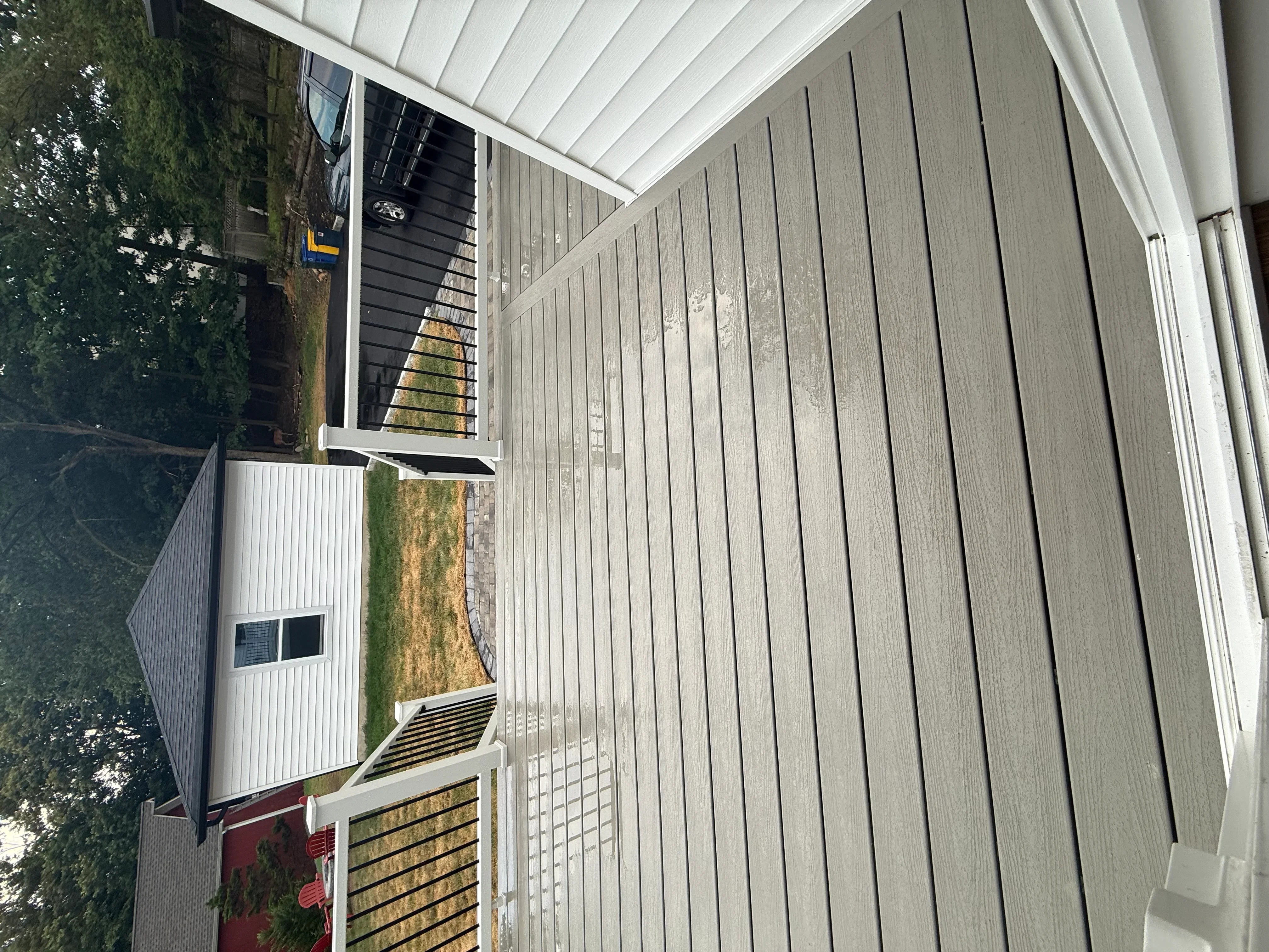 Gray standing seam metal roof with white trim, gutters, and downspouts on residential structure