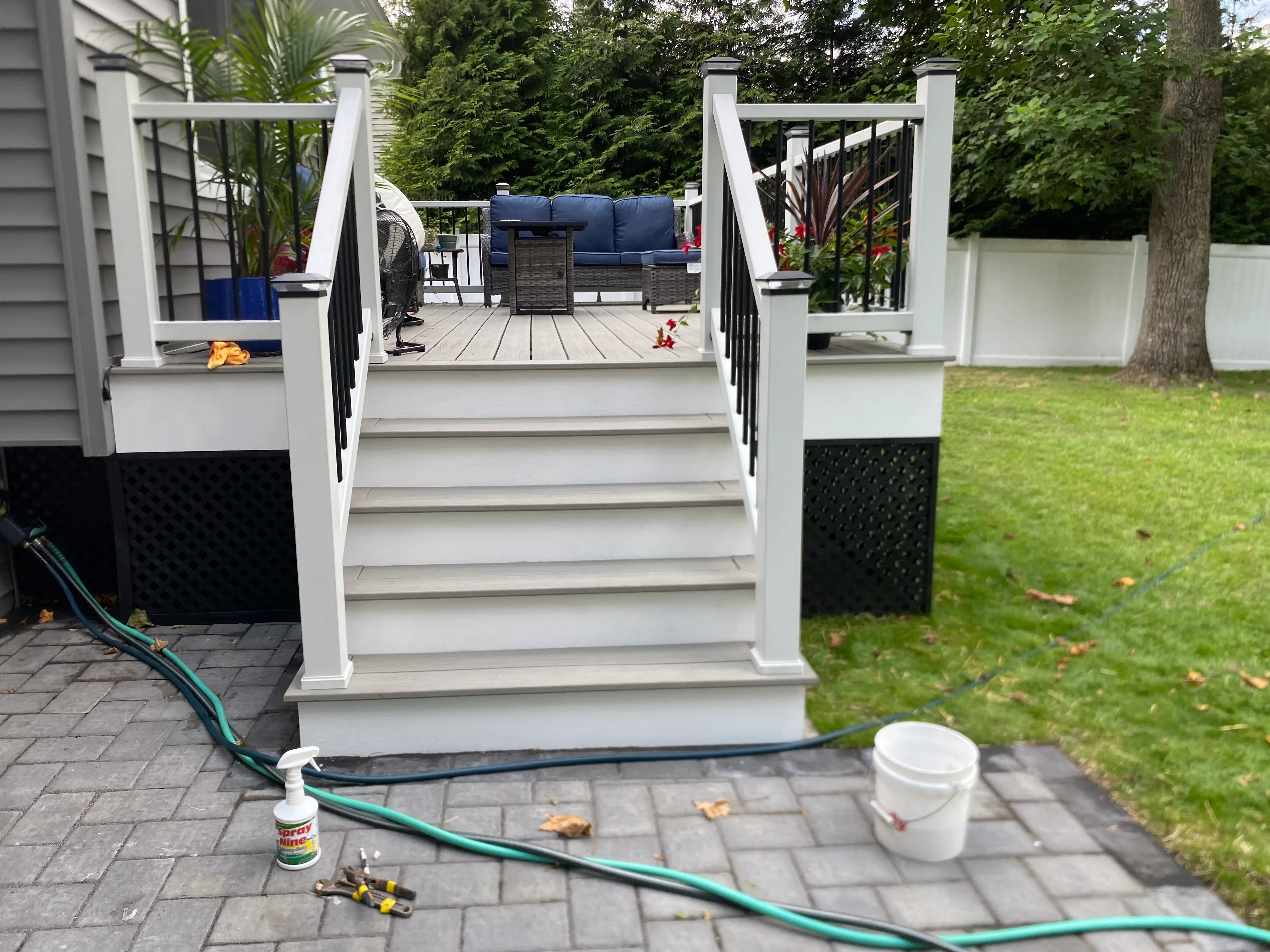 Elevated composite deck with white railings, black balusters, and integrated planters